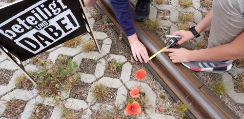 1. Kinder- und Jugendbeteiligung: Teilnehmer*innen messen die Schienenbreite